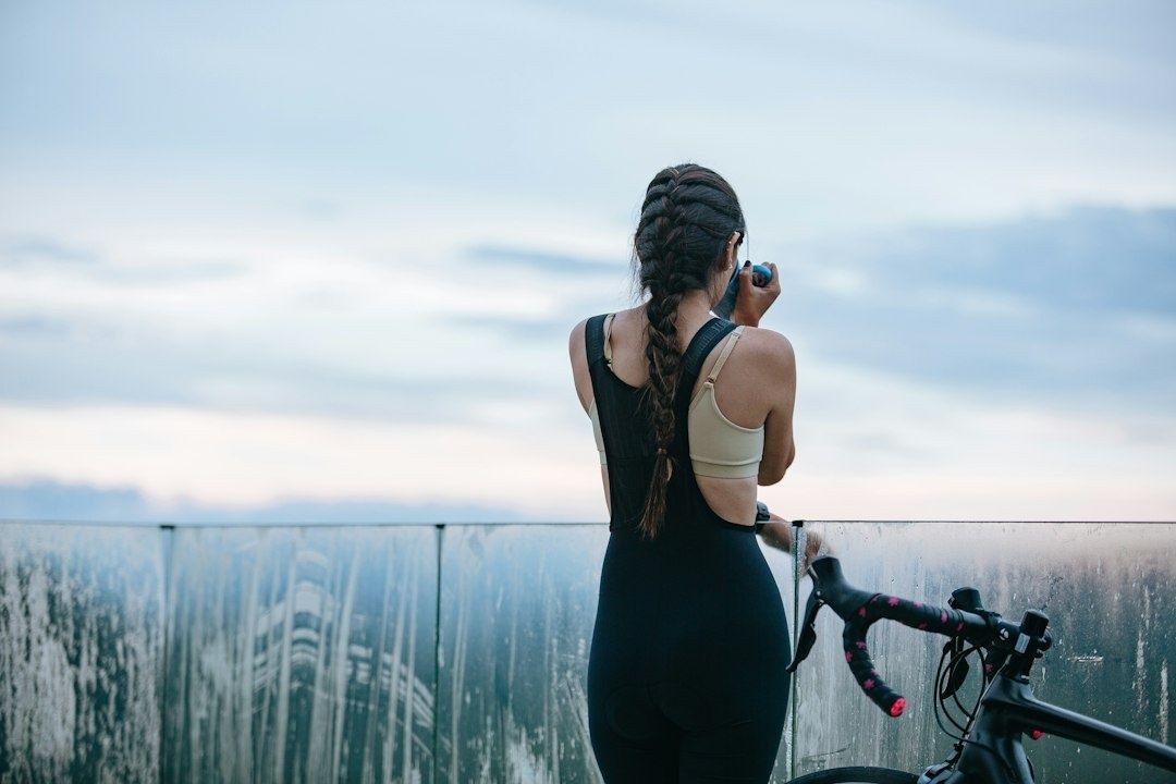 Fietster met sporthorloge kijkt uit over het water tijdens een pauze