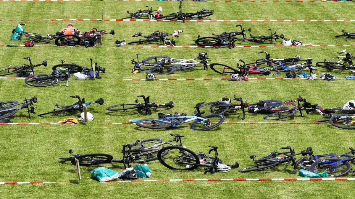 Rijen fietsen en helmen in een afgezette triatlonwisselzone