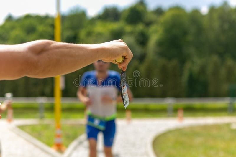 Uitgestrekte hand met een klein voorwerp bij een sportevenement